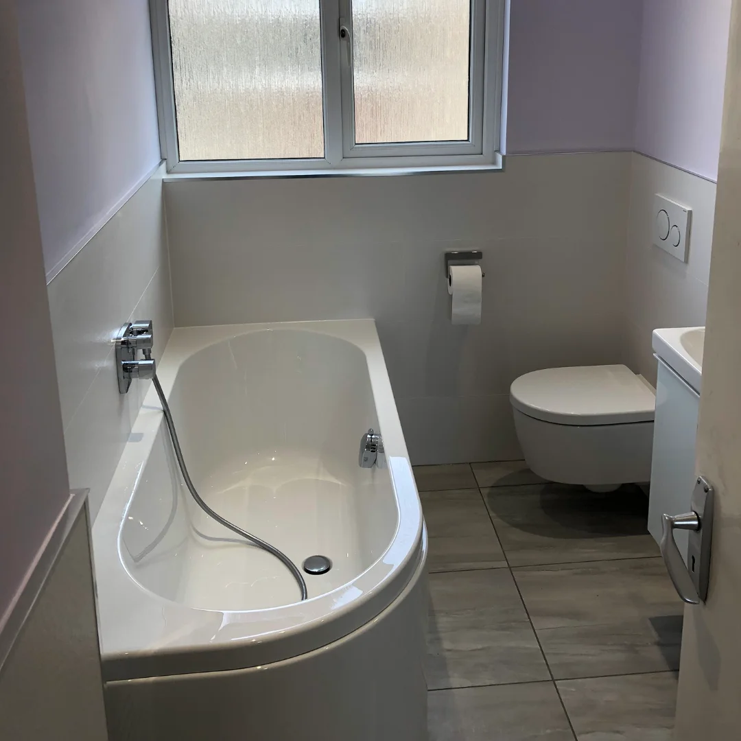 White Bathtub with white W/C and sink in lilac bathroom renovation